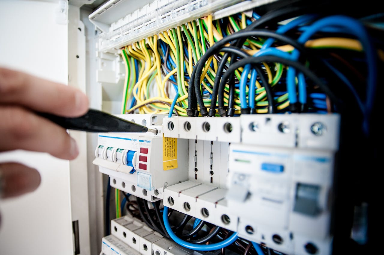 Crafting Captivating Headlines: Your awesome post title goes here Hand of electrician working on a circuit breaker panel with colorful wires, ensuring safe electrical connections.